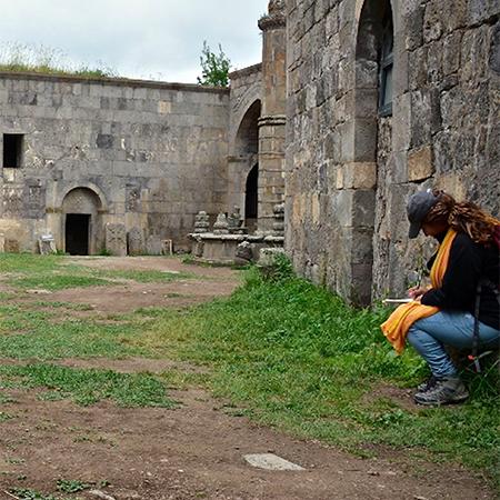 		Person takes notes amidst old stone buildings
	