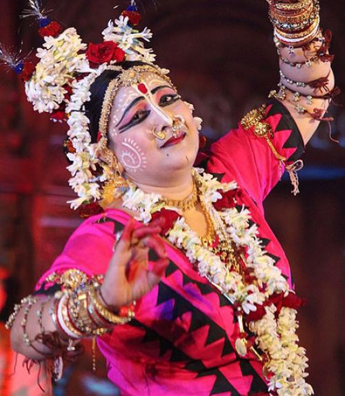 		 A temple dancer in India wearing flowers and lots of jewelry.
	