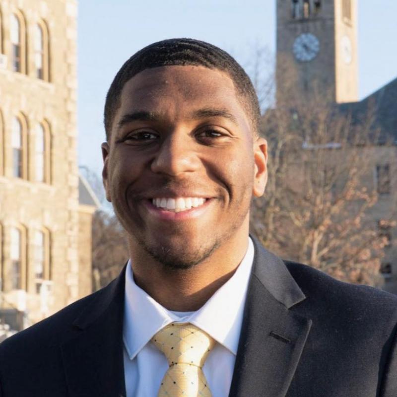 Laurence Minter '21 in a suit and tie, in front of a clocktower.