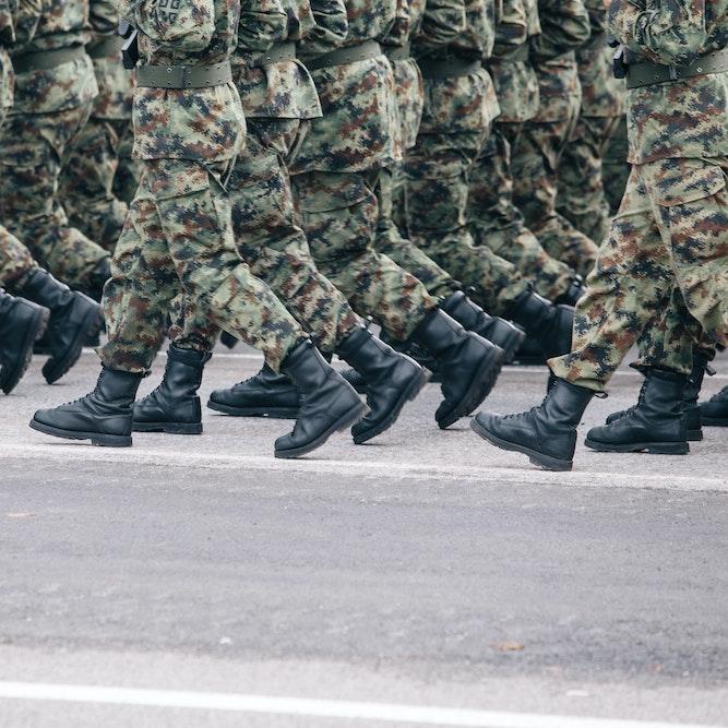 		Soldiers dressed in army camouflage march in formation 
	