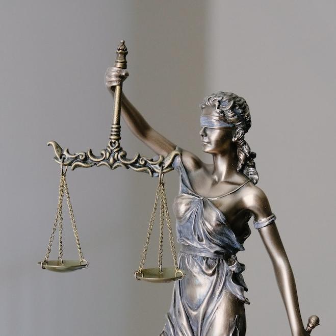 		metal sculpture of a figure blindfolded and holding scales
	