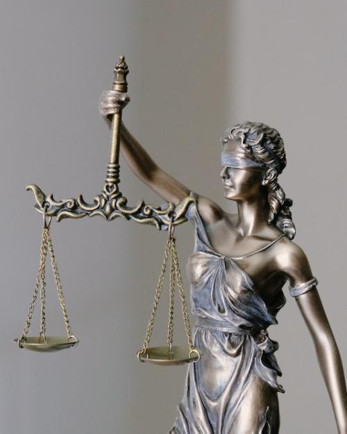 		metal sculpture of a figure blindfolded and holding scales
	