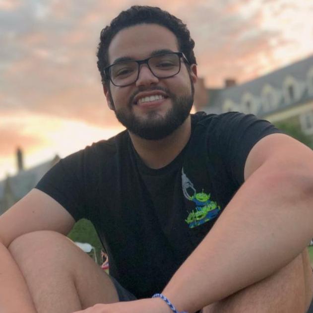Gabriel Vergara '21 sitting on a grassy lawn.