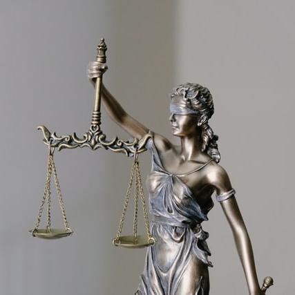 A blindfolded bronze woman in a toga holding a set of scales