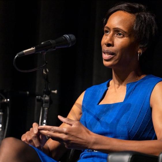 Person speaking authoritatively from a stage