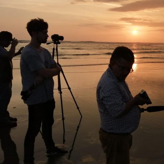 		People silhouetted against a sunset over water
	