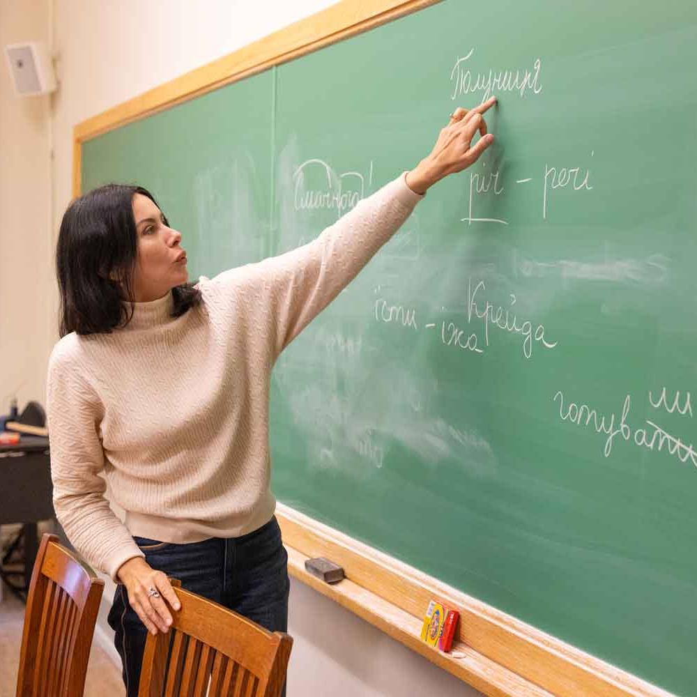 woman showing Ukrainian words on chalkboard