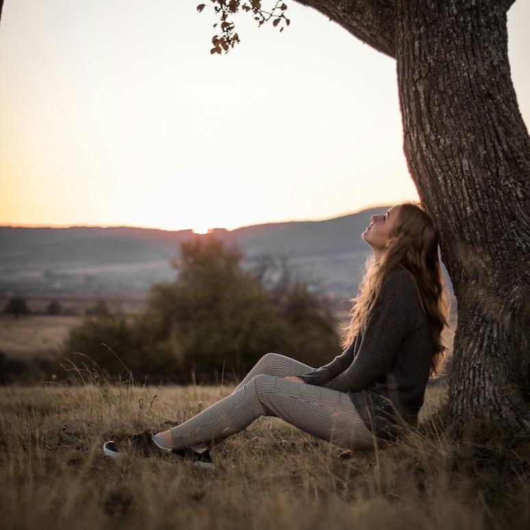 Person sitting under a tree