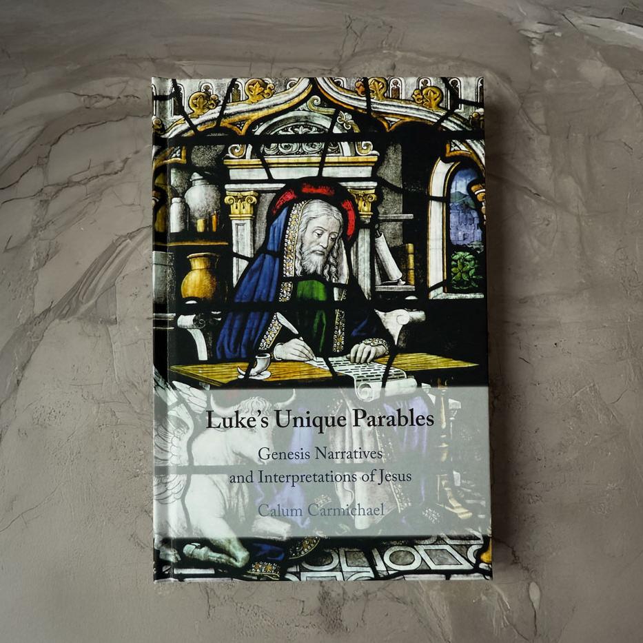 Image of aMedieval scholar sitting at a table writing with a quill pen