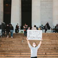 Person holding protest sign on steps