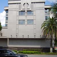  Grey concrete building, palm trees, blue sky