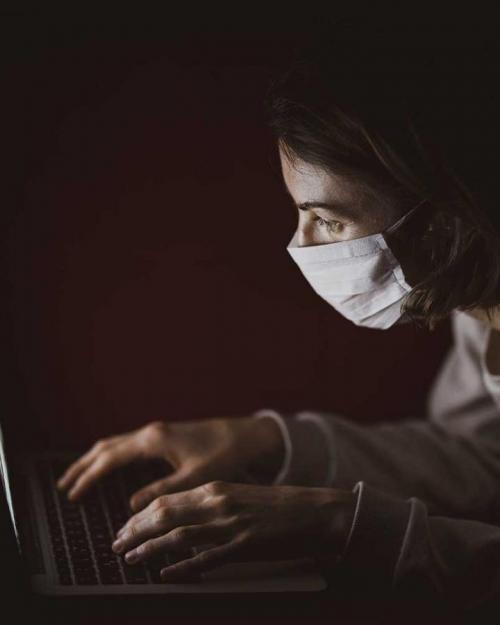 Person hunching fearfully over a computer