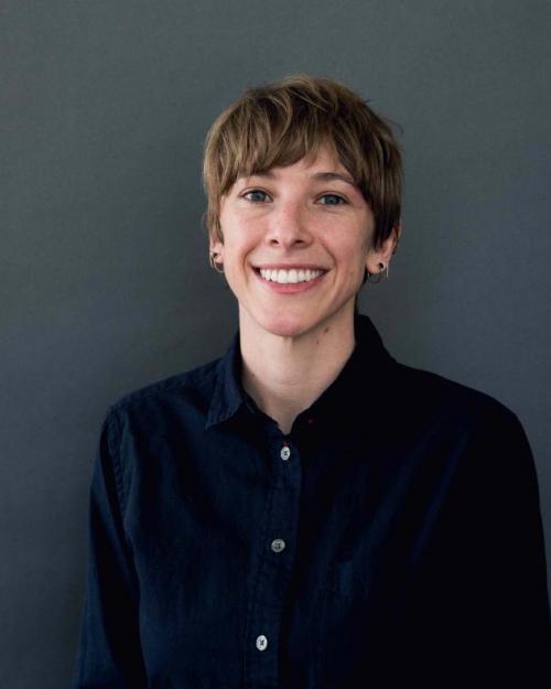 Natalie Wolchover wearing a blck shirt and earrings
