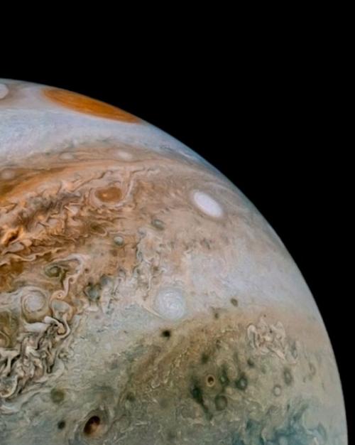 Jupiter with bands of swirling color and a red spot at top of sphere.
