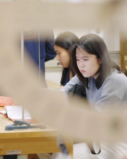 Person looks carefully at physics lab equipment