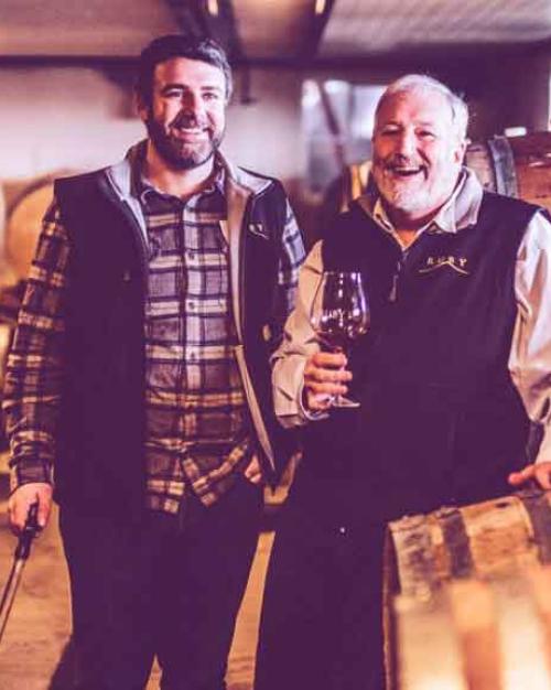 two men by barrels of wine