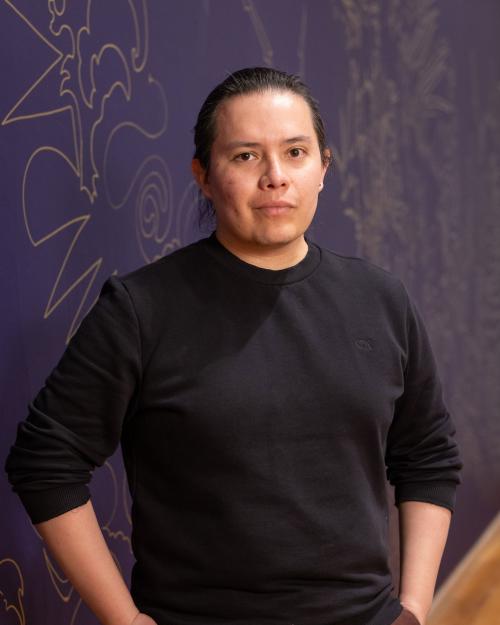 person standing next to a wall with artwork