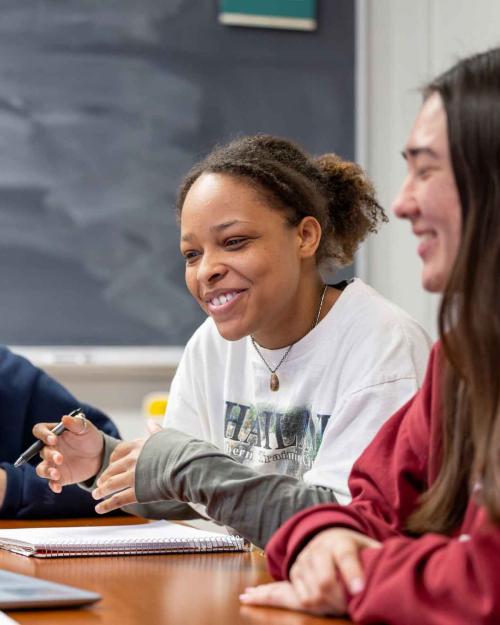 three people smiling sitting a table