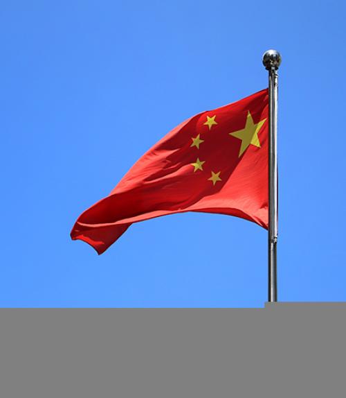  Red flag with yellow stars against a blue sky