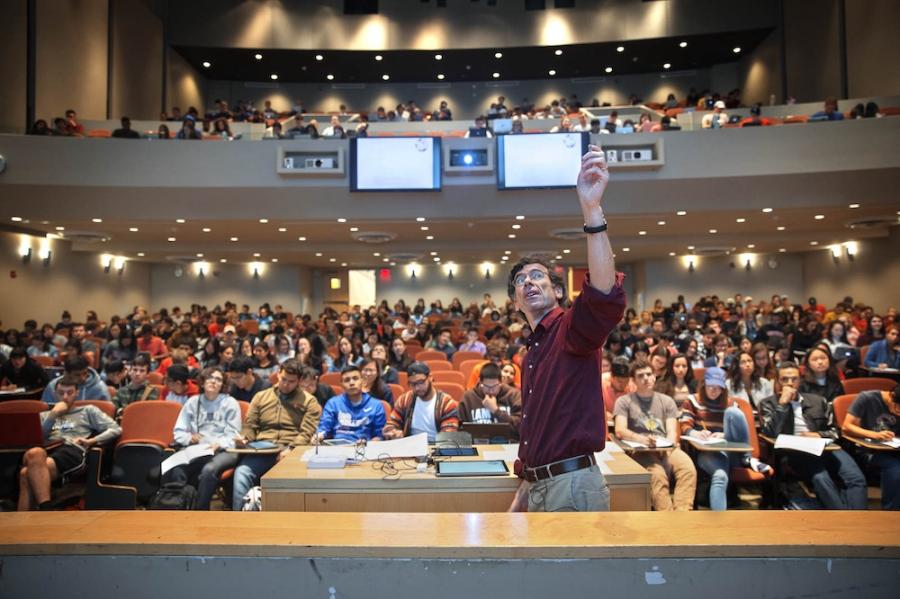 Networks course in 2017 An instructor on a platform, pointing upwards while hundreds of students watch from seats in an auditorium