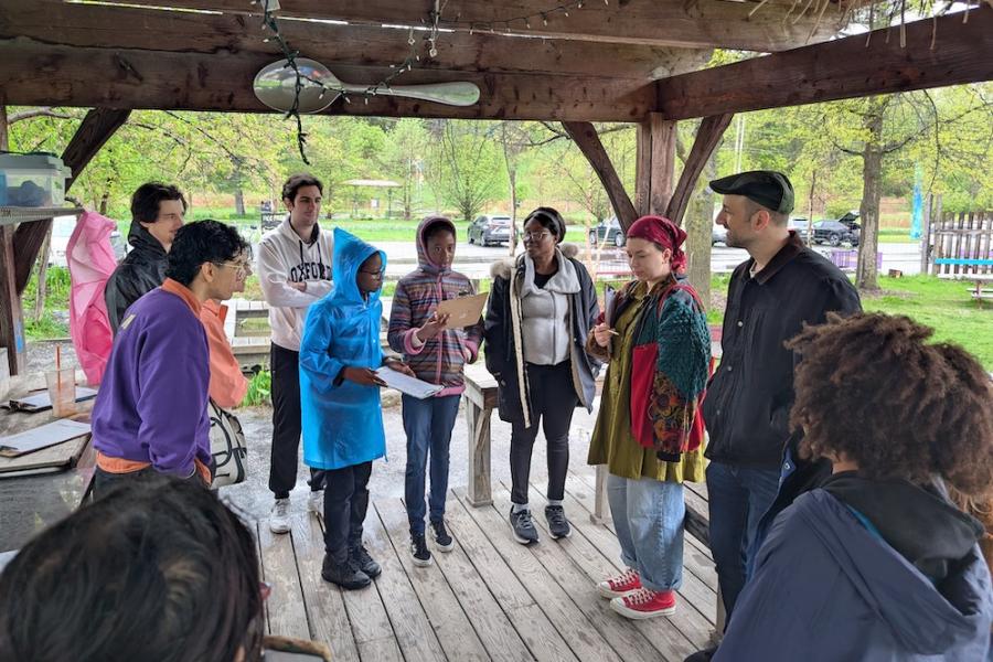 Several people standing in a wood pavilion